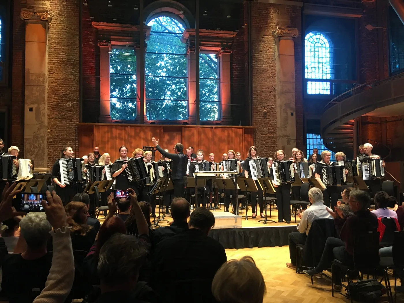 London Accordion Orchestra standing with their accordions on stage at LSO St Luke's